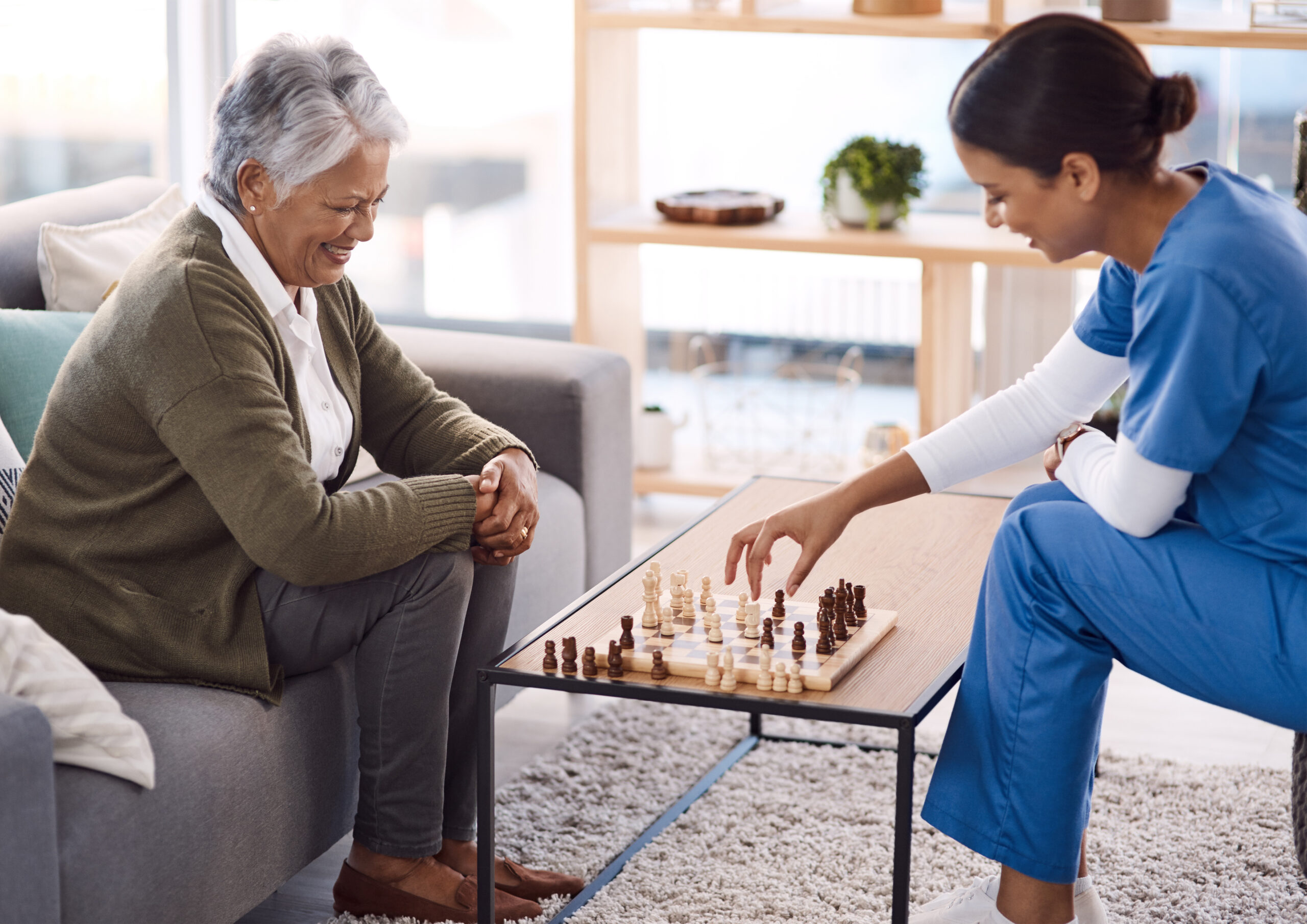 Shot of a young nurse playing chess with a senior woman in a retirement home